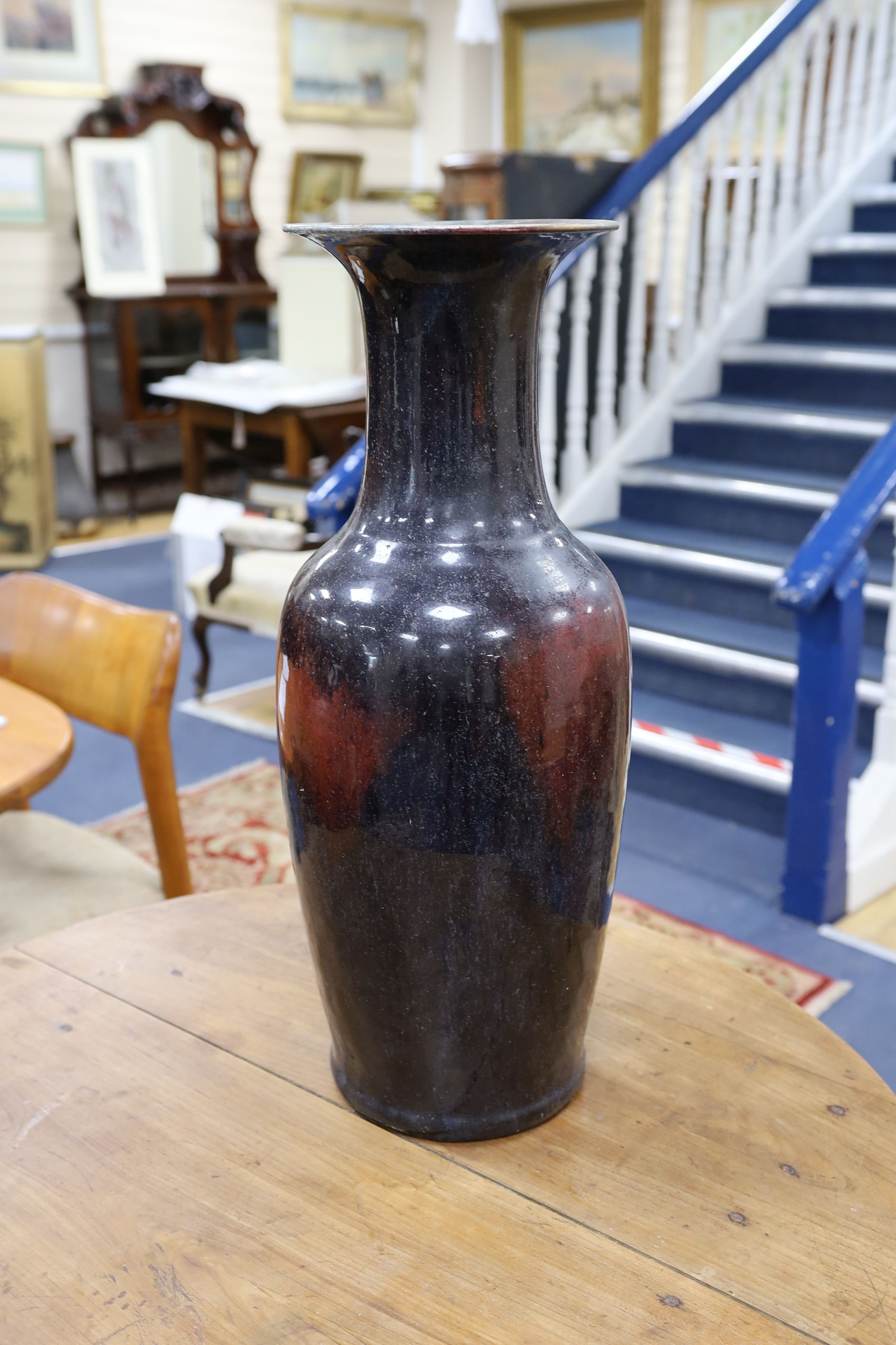 A large Chinese sang de boeuf glazed vase on carved wooden stand., Vase 61 cms high not including stand.